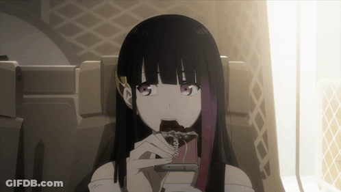 A Girl With Long Black Hair Is Sitting In A Chair Eating A Chocolate Bar GIF