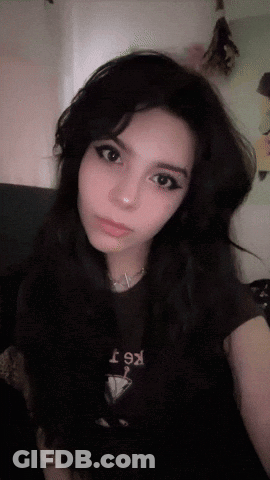 A Girl With Long Black Hair Is Wearing A T-Shirt That Says Kt GIF