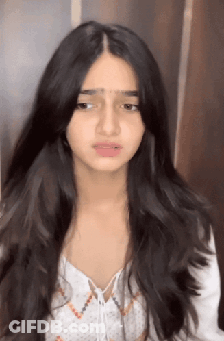 A Girl With Long Black Hair Is Wearing A White Shirt GIF