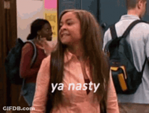 A Girl With Long Hair And A Backpack Is Standing In A Hallway With Other People . GIF
