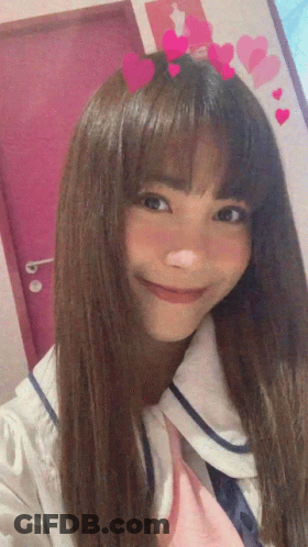 A Girl With Long Hair And Hearts On Her Head Smiles For The Camera GIF