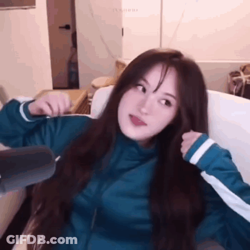 A Girl With Long Hair Is Sitting On A Couch . GIF