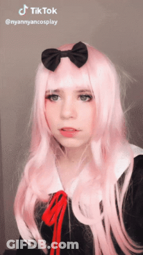 A Girl With Long Pink Hair And A Black Bow On Her Head Has A Tiktok Watermark GIF