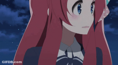 A Girl With Long Red Hair And Blue Eyes Looks At The Camera GIF
