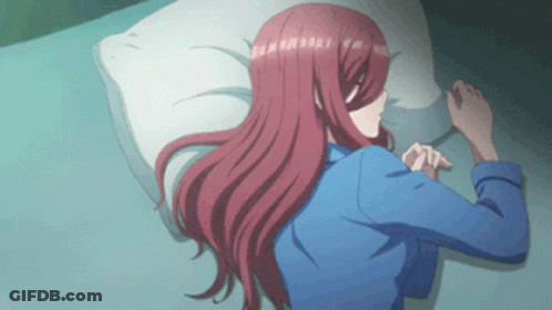 A Girl With Long Red Hair Is Laying On A Bed GIF