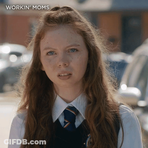 A Girl With Long Red Hair Is Wearing A Workin ' Moms Shirt GIF