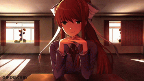 A Girl With Long Red Hair Sits At A Table With Her Hands On Her Chin GIF