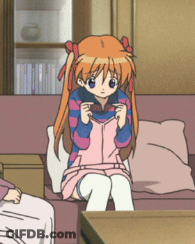 A Girl With Orange Hair Is Sitting On A Couch In A Living Room GIF