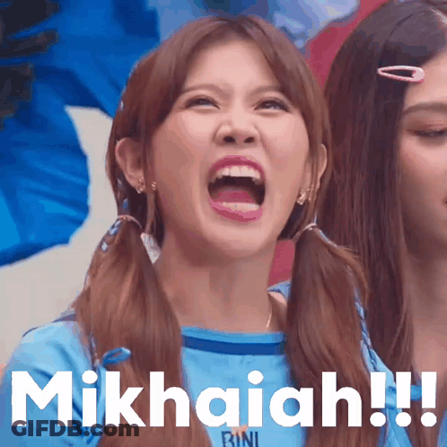 A Girl With Pigtails And A Blue Shirt That Says Bini Is Making A Funny Face GIF