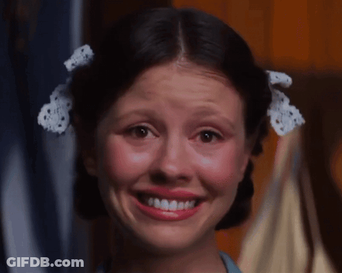 A Girl With Pigtails And A Bow In Her Hair Smiles For The Camera GIF