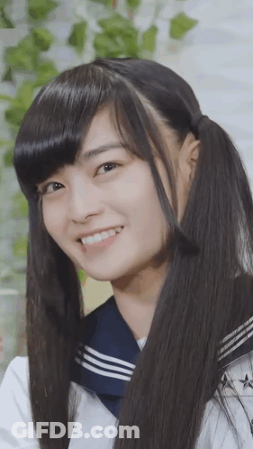 A Girl With Pigtails And A Sailor Uniform Smiles For The Camera GIF
