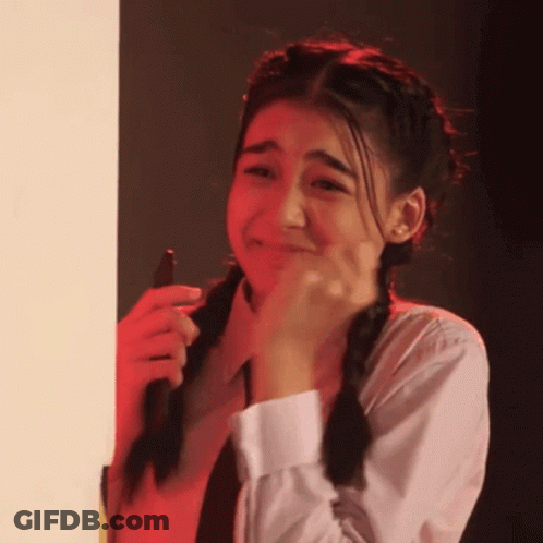 A Girl With Pigtails Is Crying While Holding A Cell Phone In Her Hand . GIF