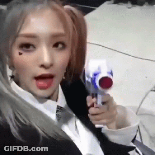 A Girl With Pigtails Is Holding A Toy Gun In Her Hand . GIF