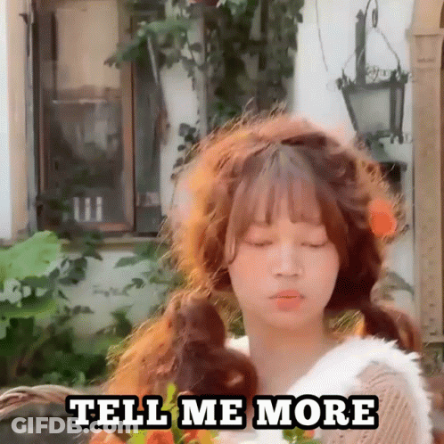 A Girl With Pigtails Is Standing In Front Of A Building And Says Tell Me More . GIF