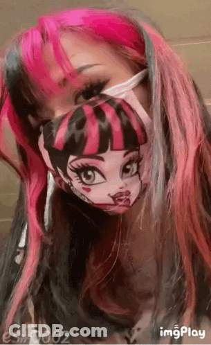 A Girl With Pink And Black Hair Is Wearing A Monster High Mask . GIF
