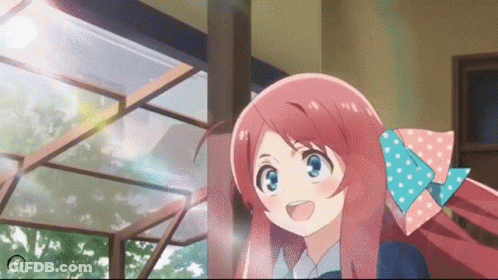 A Girl With Pink Hair And A Blue Bow In Her Hair Is Smiling GIF