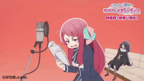 A Girl With Pink Hair And Blue Eyes Stands In Front Of A Microphone With A Bow In Her Hair GIF