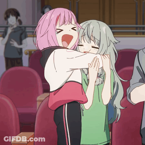 A Girl With Pink Hair Is Hugging Another Girl GIF