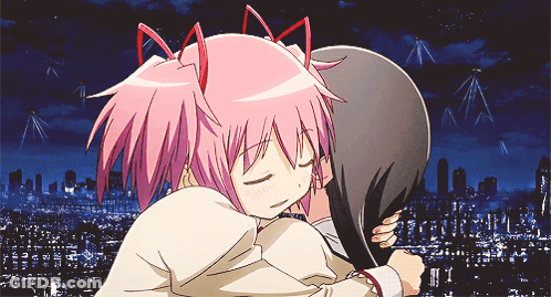 A Girl With Pink Hair Is Hugging Another Girl With Dark Hair GIF