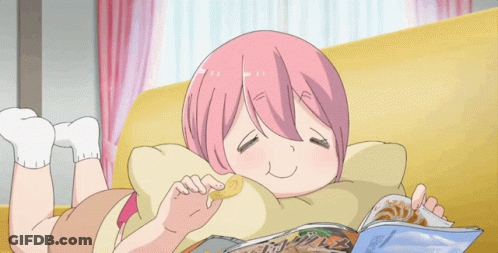 A Girl With Pink Hair Is Laying On A Couch Eating Chips And Reading A Magazine GIF