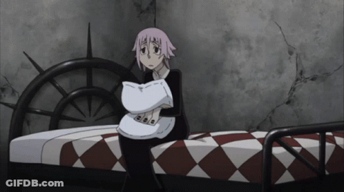 A Girl With Pink Hair Is Sitting On A Bed GIF