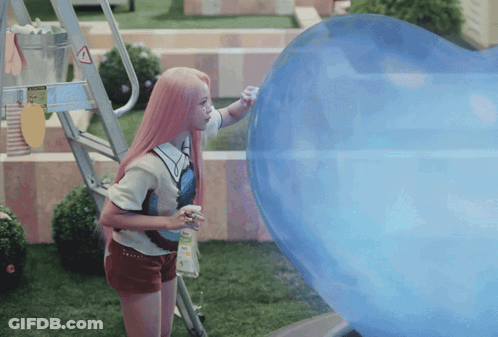 A Girl With Pink Hair Is Standing Next To A Large Blue Balloon GIF