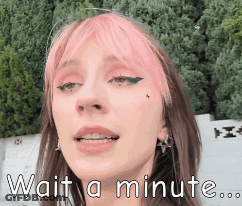 A Girl With Pink Hair Is Waiting For A Minute GIF