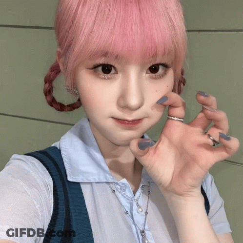 A Girl With Pink Hair Is Wearing A Blue Necklace GIF