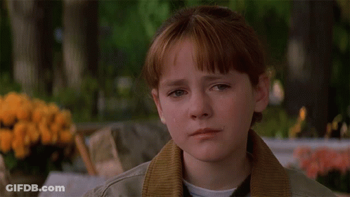 A Girl With Red Hair And A Brown Jacket Looks Down GIF