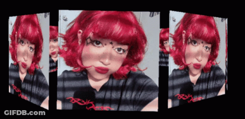 A Girl With Red Hair And A Striped Shirt Has A Reflection Of Herself In A Mirror GIF