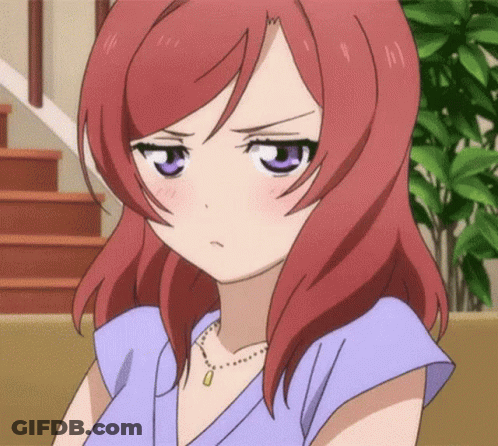 A Girl With Red Hair And Purple Eyes Is Wearing A Necklace And A Blue Shirt . GIF