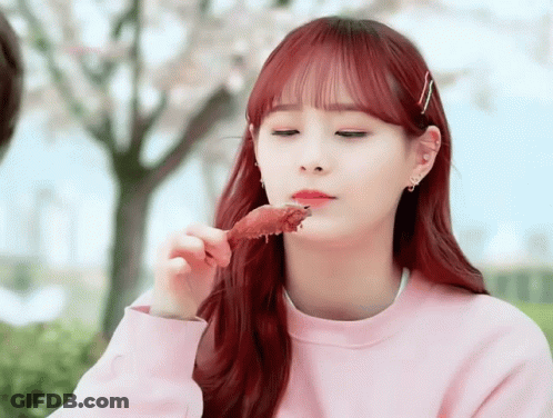 A Girl With Red Hair Eating A Piece Of Meat GIF