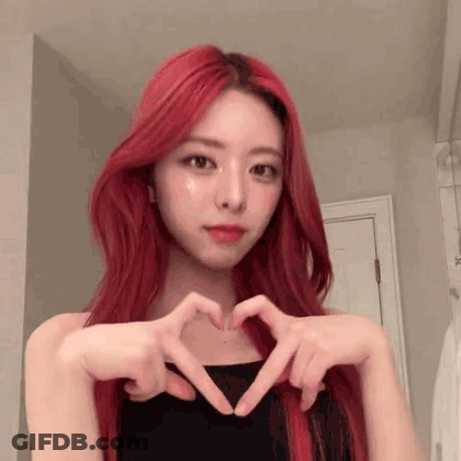 A Girl With Red Hair Is Making A Heart With Her Hands . GIF
