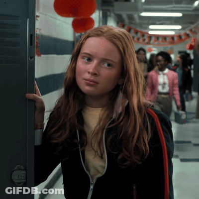 A Girl With Red Hair Is Standing In A Hallway GIF
