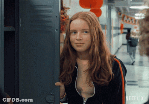 A Girl With Red Hair Is Standing In Front Of A Locker With Netflix Written On It GIF