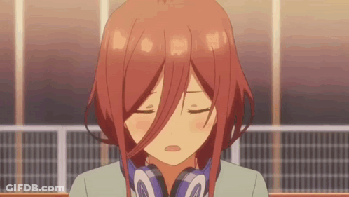 A Girl With Red Hair Is Wearing Headphones And Making A Face . GIF