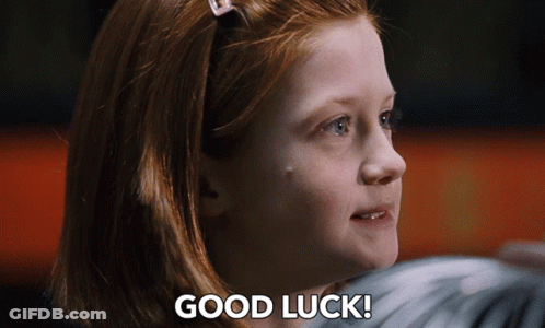 A Girl With Red Hair Says " Good Luck " In Front Of Her Face GIF