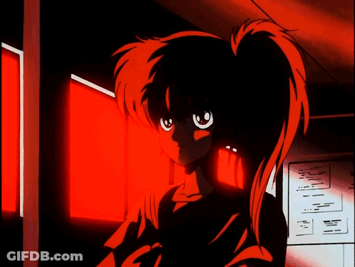 A Girl With Red Hair Stands In Front Of A Red Light GIF