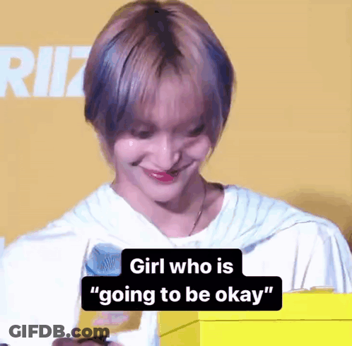 A Girl With Short Hair Is Smiling And Holding A Yellow Box With The Words `` Girl Who Is Going To Be Okay '' On It . GIF