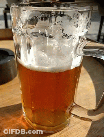 A Glass Filled With A Brown Liquid With Foam On Top GIF
