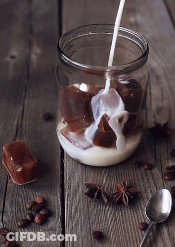 A Glass Jar Filled With Milk And Ice Cubes GIF