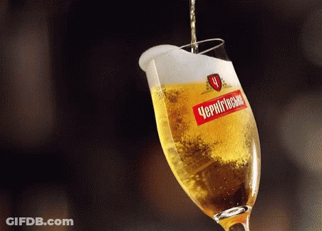 A Glass Of Beer With A Label That Says " Чернігівське " Is Being Poured Into It GIF