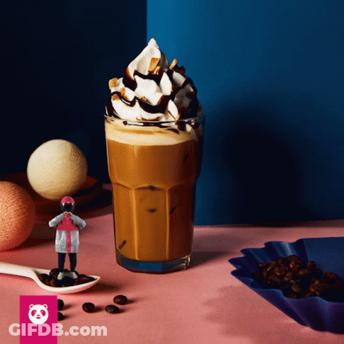 A Glass Of Coffee With Whipped Cream And Chocolate Sauce On Top GIF