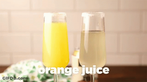 A Glass Of Orange Juice Is Being Poured Into A Glass Of Lemon Juice GIF
