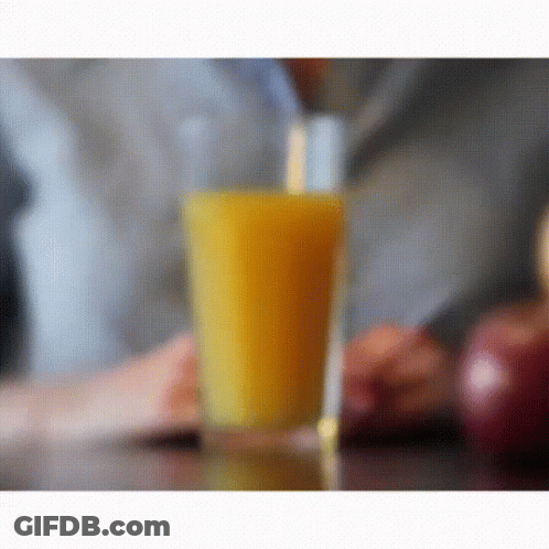 A Glass Of Orange Juice With A Straw In It GIF