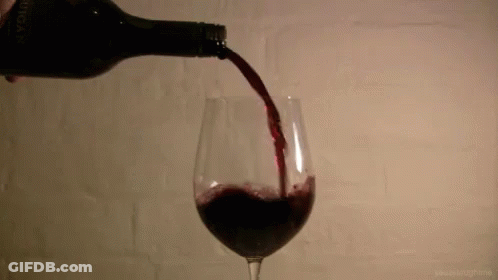 A Glass Of Red Wine Is Being Poured From A Bottle That Says " Avignon " On It GIF