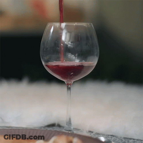 A Glass Of Red Wine Is Being Poured Into The Glass GIF