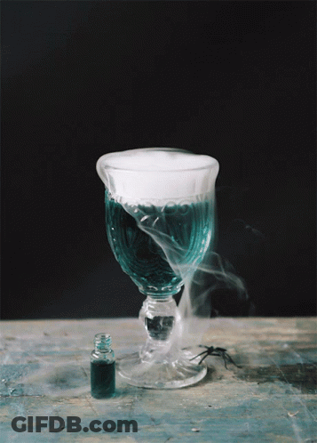 A Glass With Smoke Coming Out Of It Next To A Bottle GIF