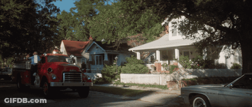 A Gmc Fire Truck Is Parked In Front Of A House GIF