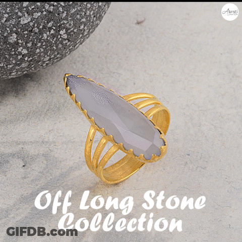 A Gold Ring With A Green Stone Sits On A Table With The Words Off Long Stone Collection Above It GIF